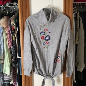 Grey turtleneck with tie in front and floral stitching